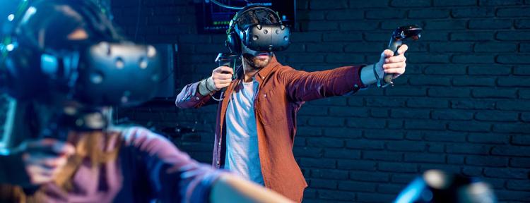 Ein Mann und eine Frau spielen ein Spiel mit einem Virtual-Reality-Headset und Gamepads